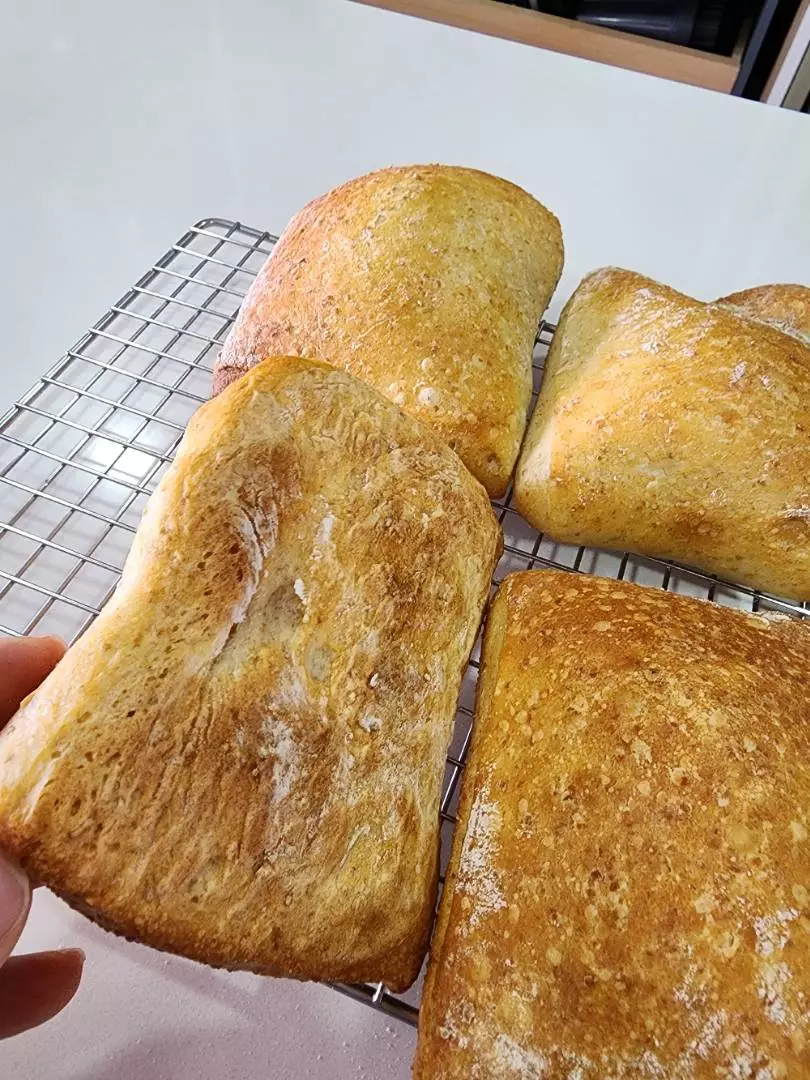 Freshly baked bread loaves cooling on a rack, baked on a Steel Craft baking steel